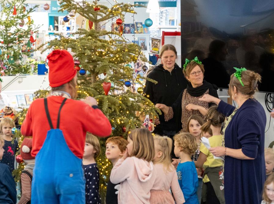 Børn danser om juletræet på Flensborg Bibliotek