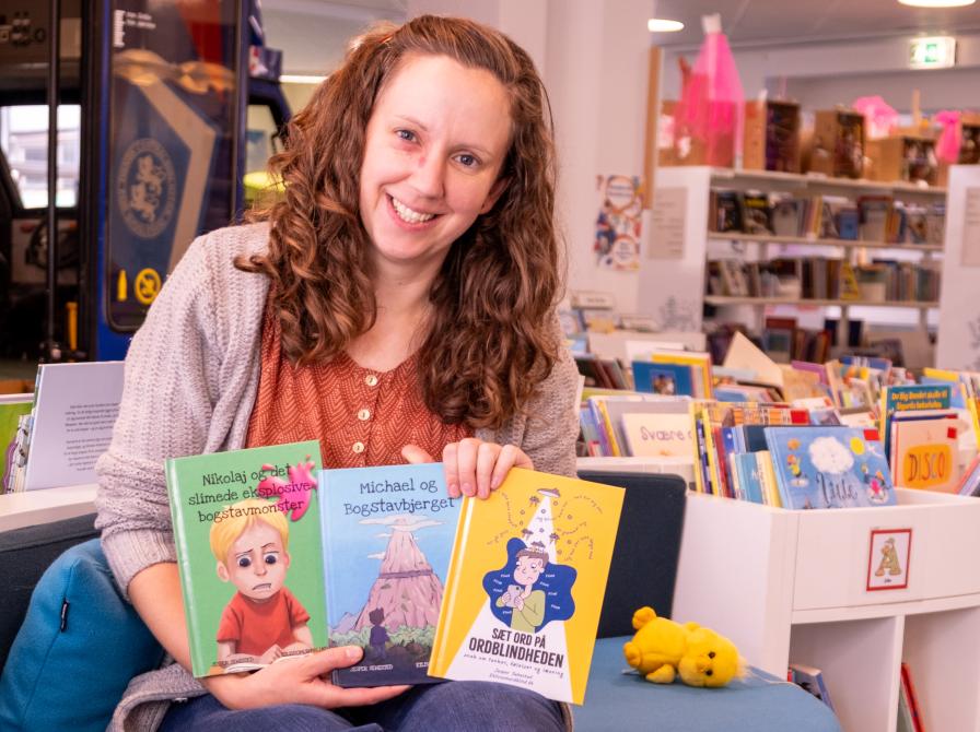 Bibliotekar Katrine med børnebøger om ordblindhed